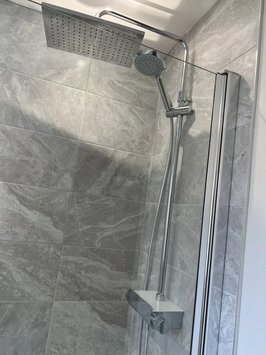 Rainfall shower head and glass screen with grey marble tiling