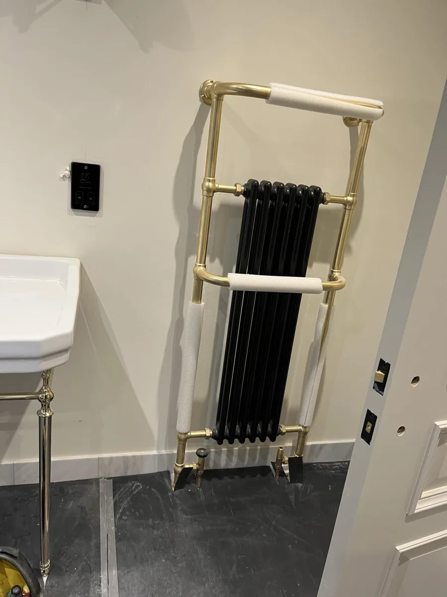 Traditional black and brass towel radiator in a period bathroom